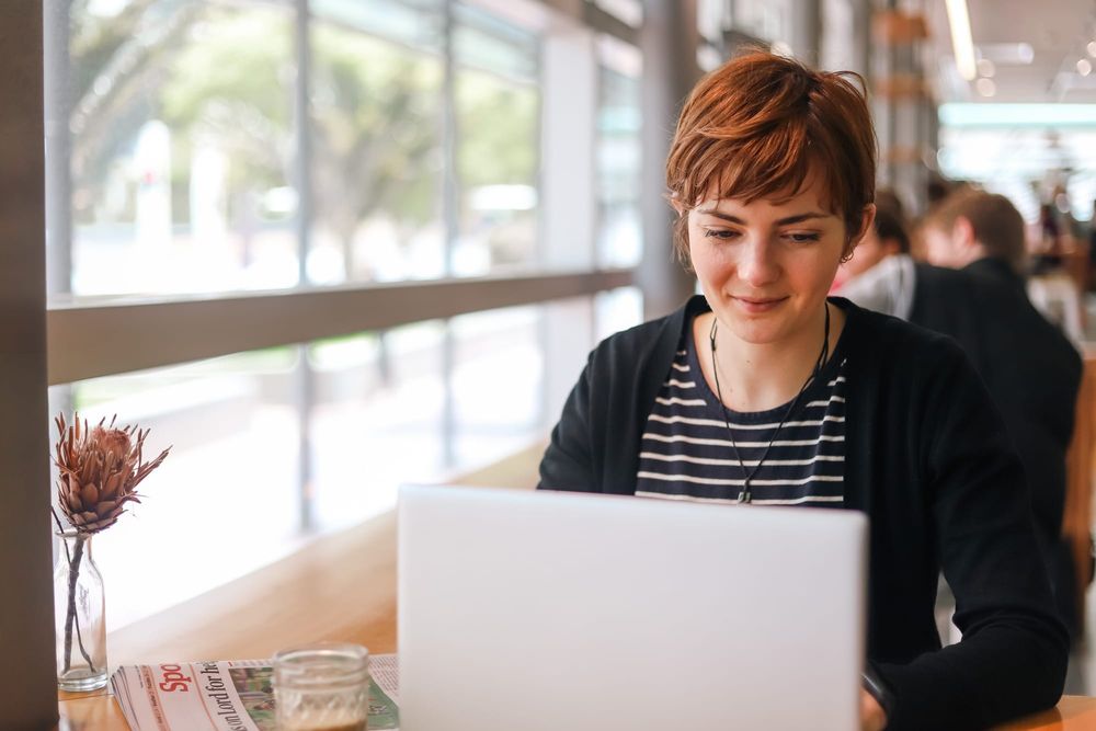 Woman working on laptop in cafe post image
