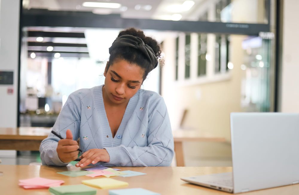 Woman writing notes with sticky papers post image