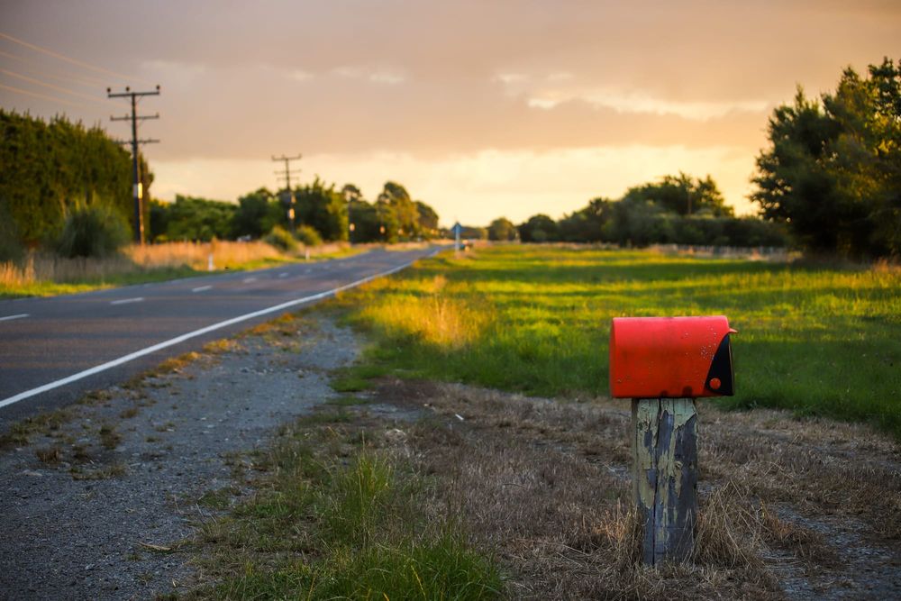 Red mailbox and countryside road post image
