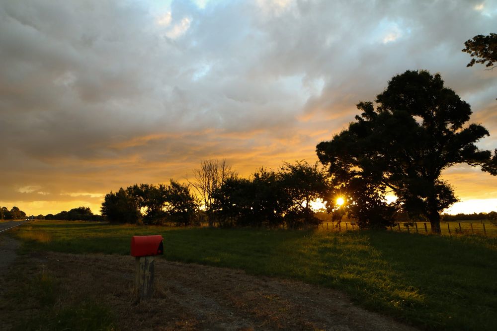 Red mailbox and sunset roadside post image