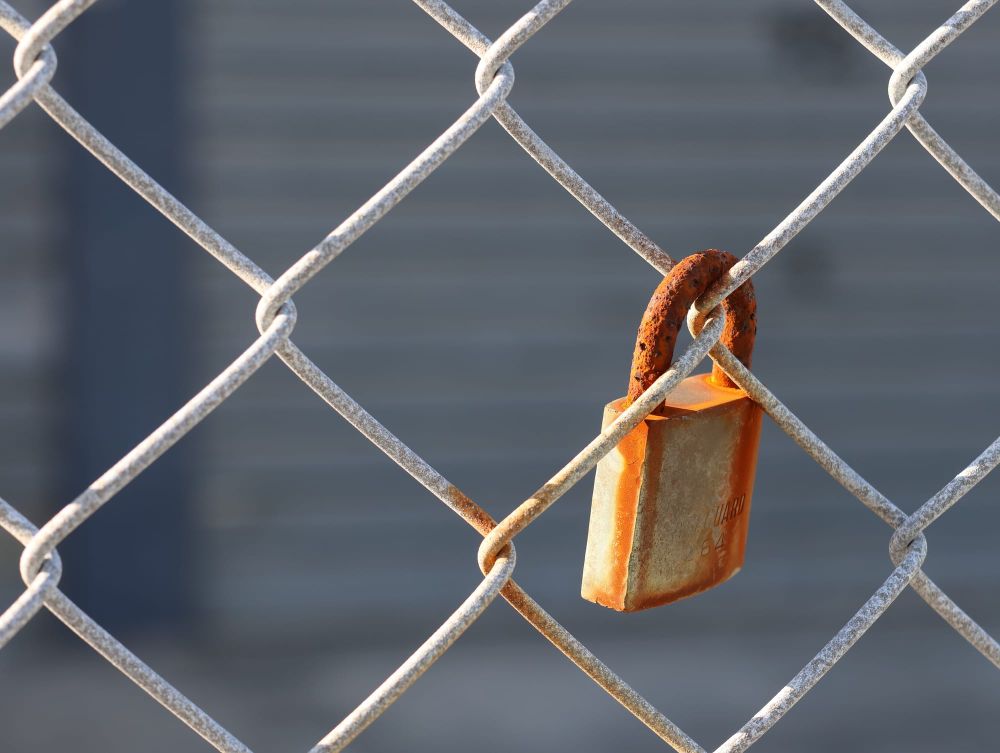 Rusted lock on the fence post image