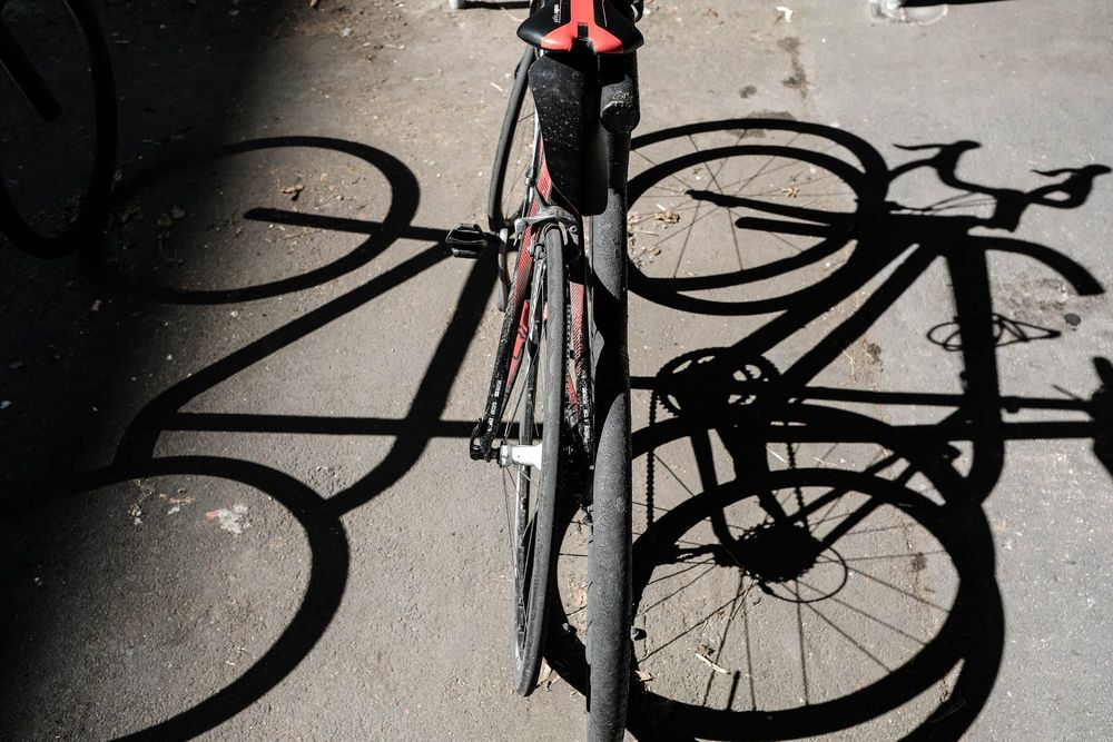 Bicycle and shadow on sunlit pavement post image