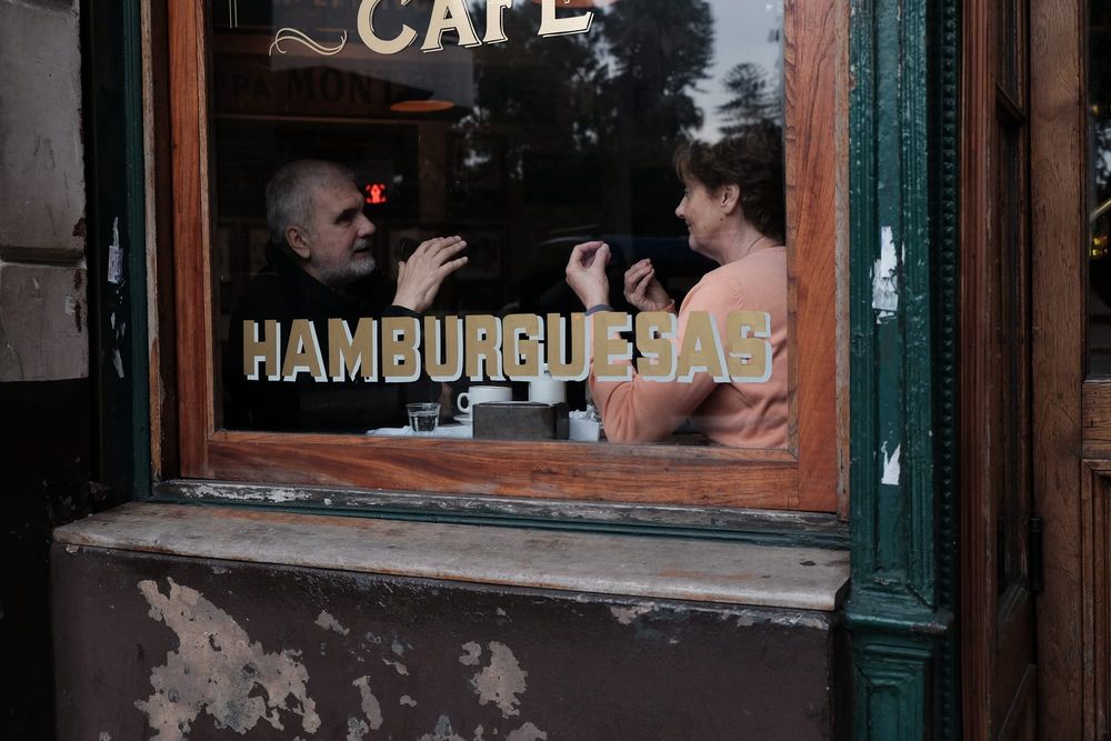 Café window with two people in conversation post image