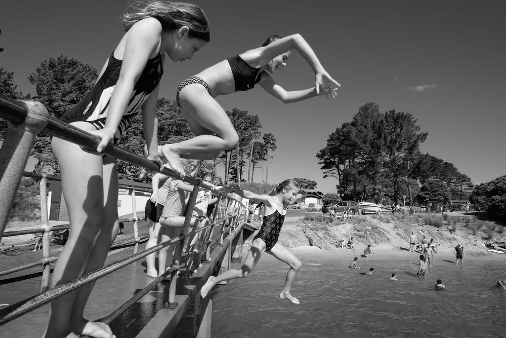 Children jumping from the railing into the water post image