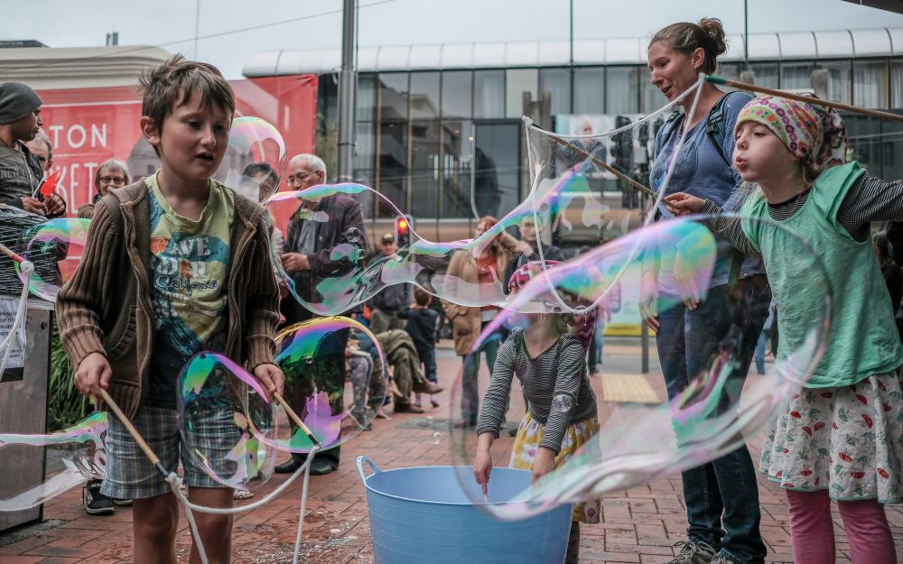 Children making bubbles at a street event post image