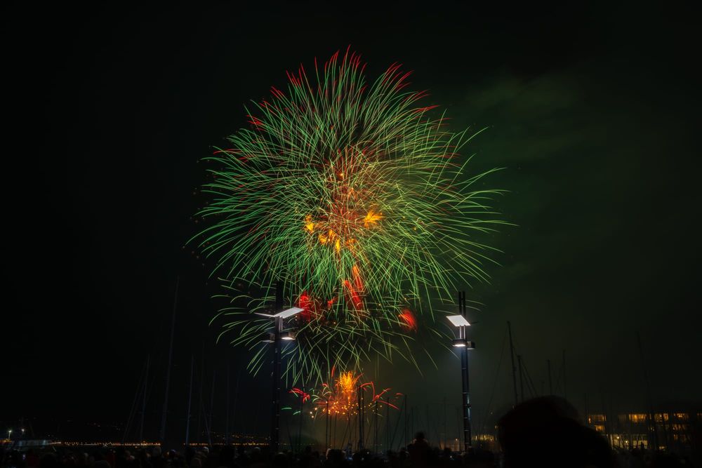 Green and orange fireworks over harbour post image