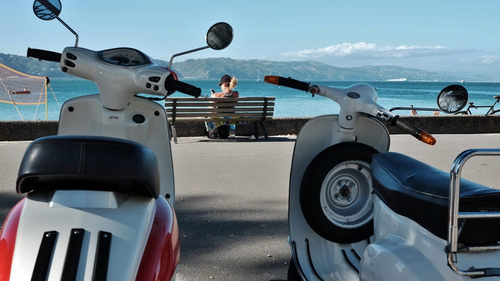 Scooters and a bench by the coastal promenade post image