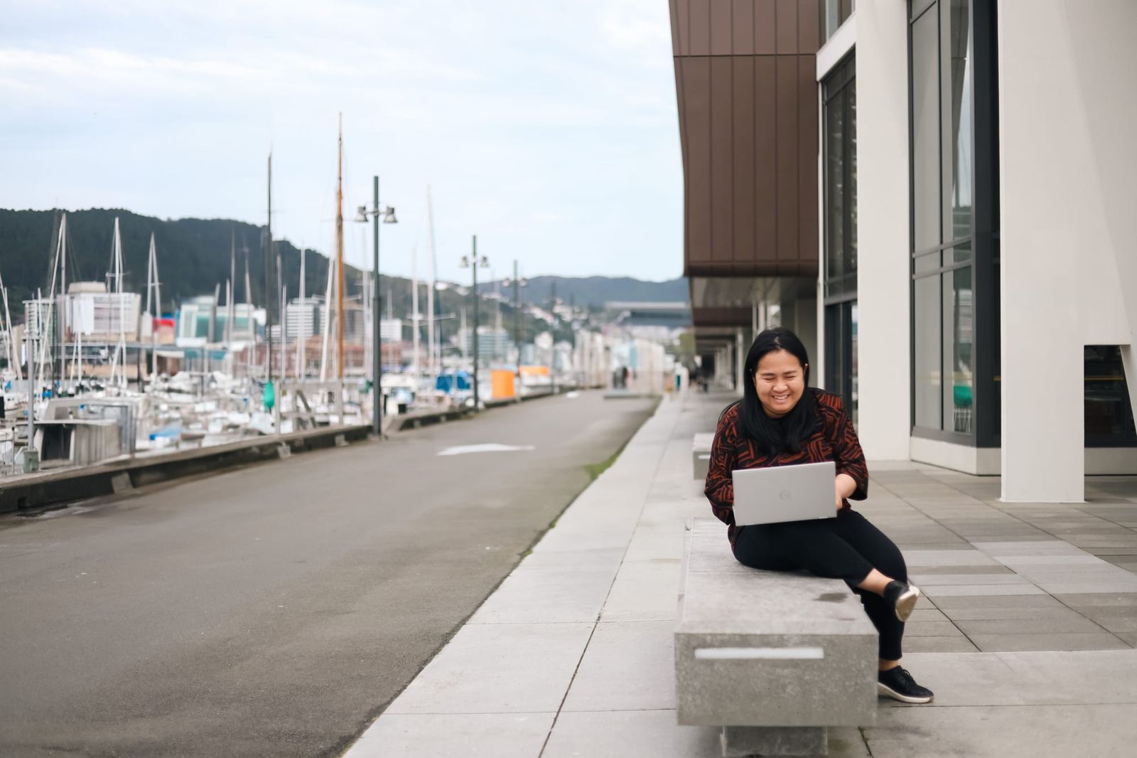 Woman smiling while working on laptop by marina
