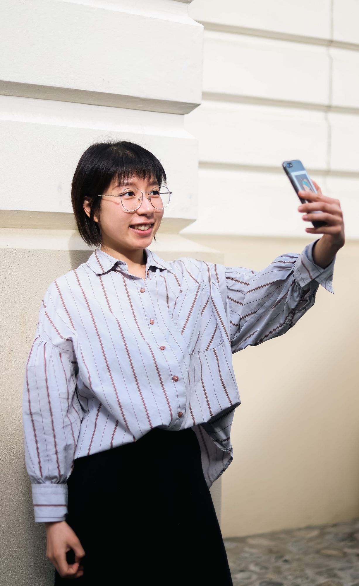 Young woman smiling while taking a selfie outdoors