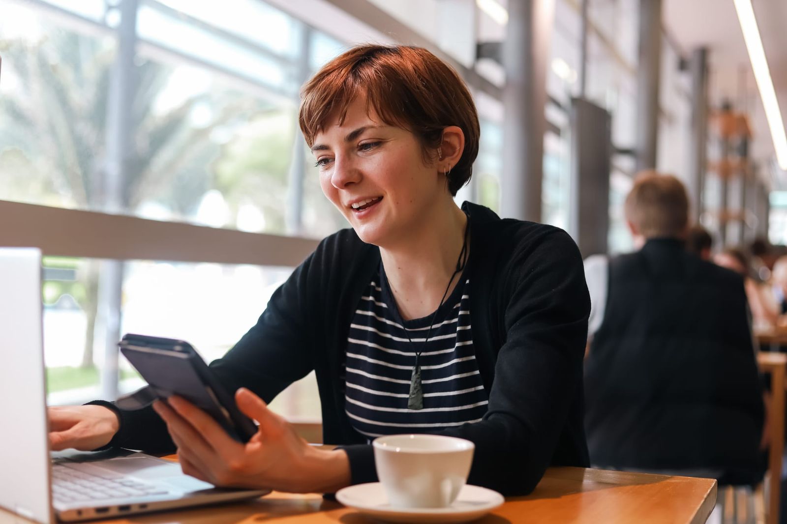 Woman chatting on phone at cafe table