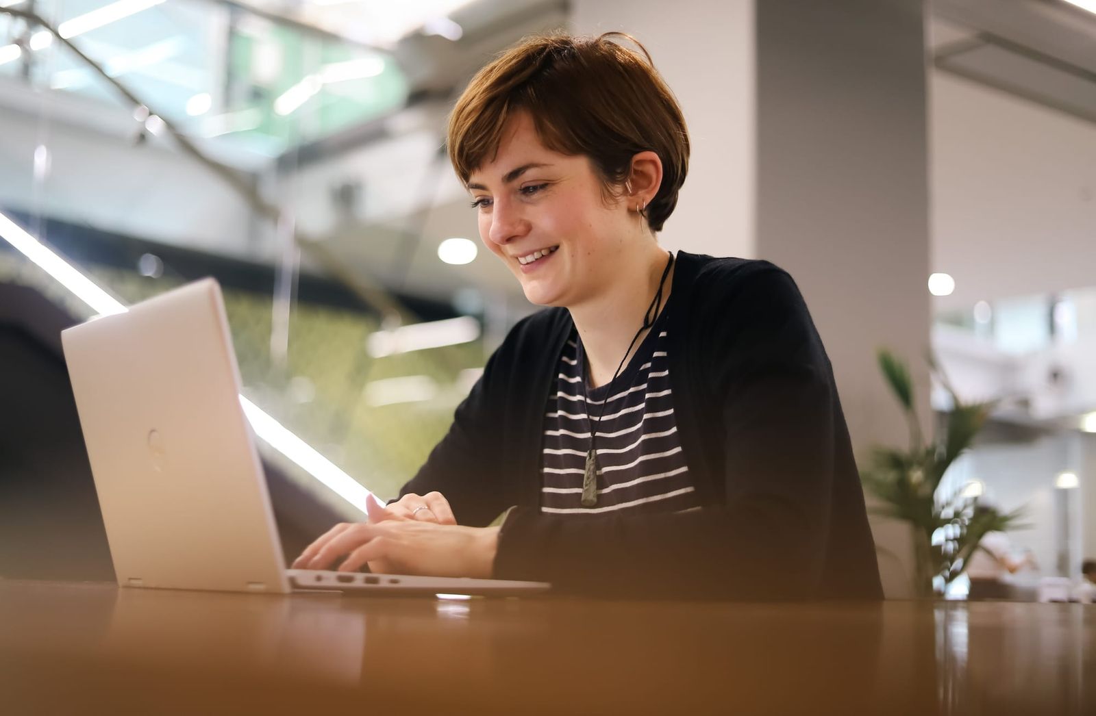 Woman smiling while working on laptop