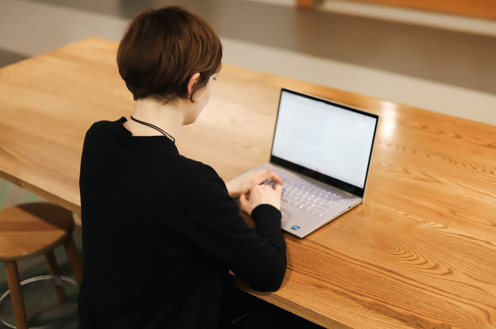 Woman working on laptop at wooden table