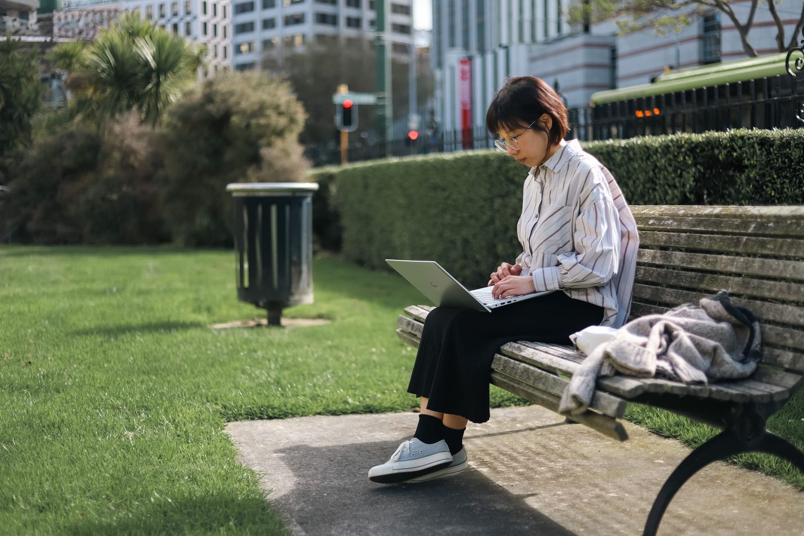 Young professional working on laptop outdoors