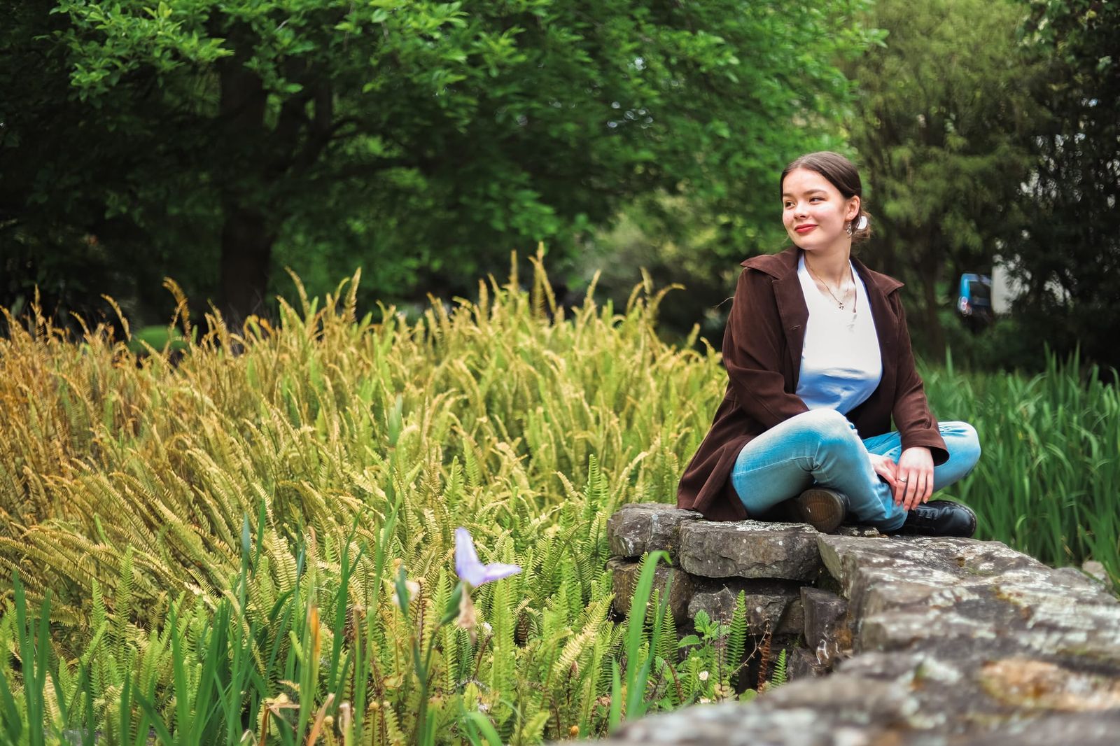 Girl sits on a stone wall