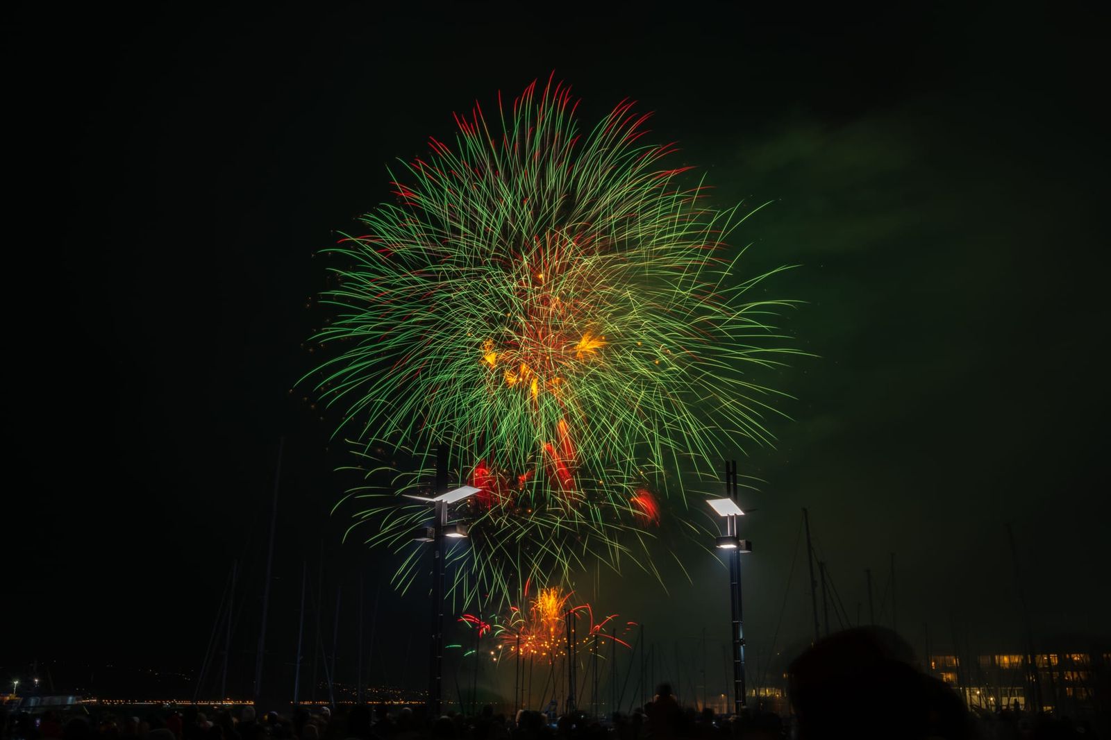 Green and orange fireworks over harbour