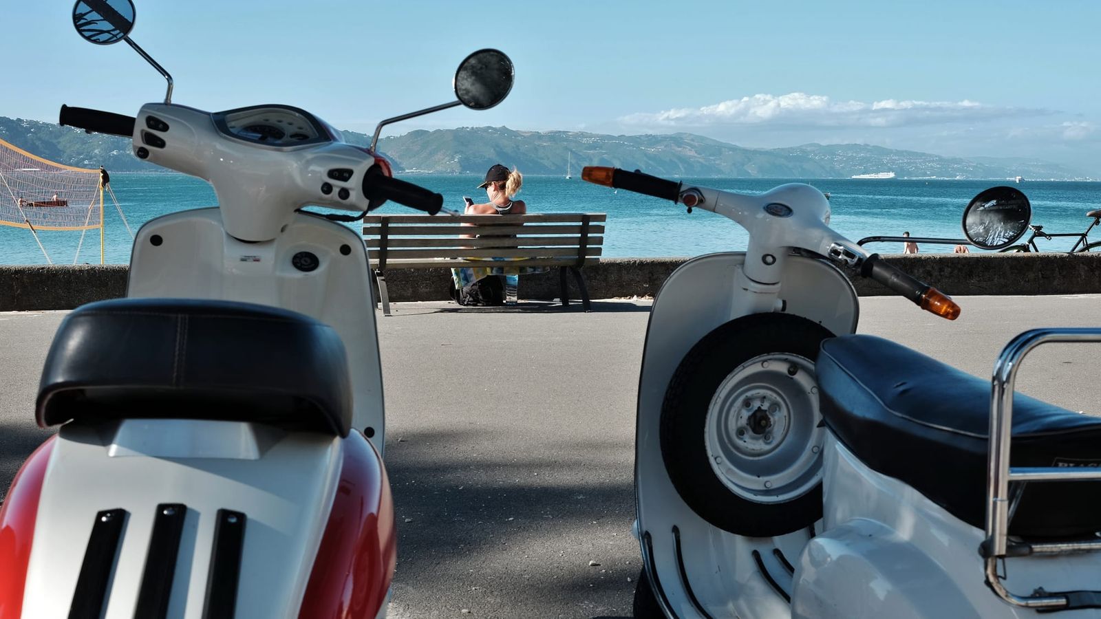 Scooters and a bench by the coastal promenade