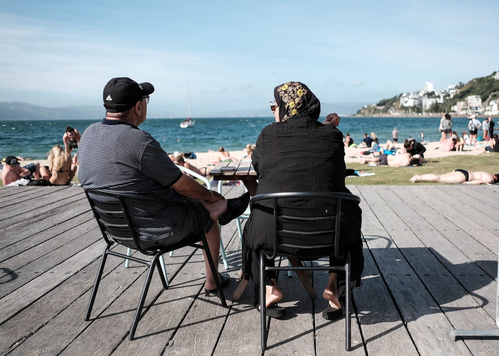 Two seated figures on a sunny deck
