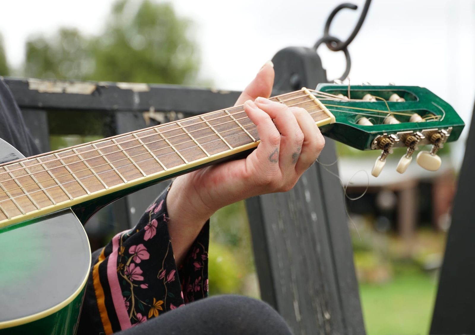 Fingers on a green guitar