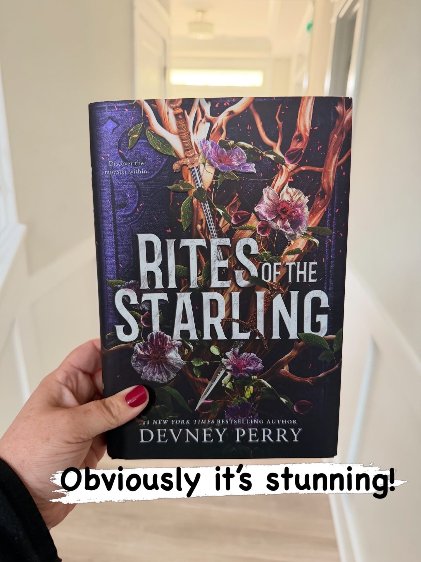 Holding the special edition book of Rites of the Starling by Devney Perry