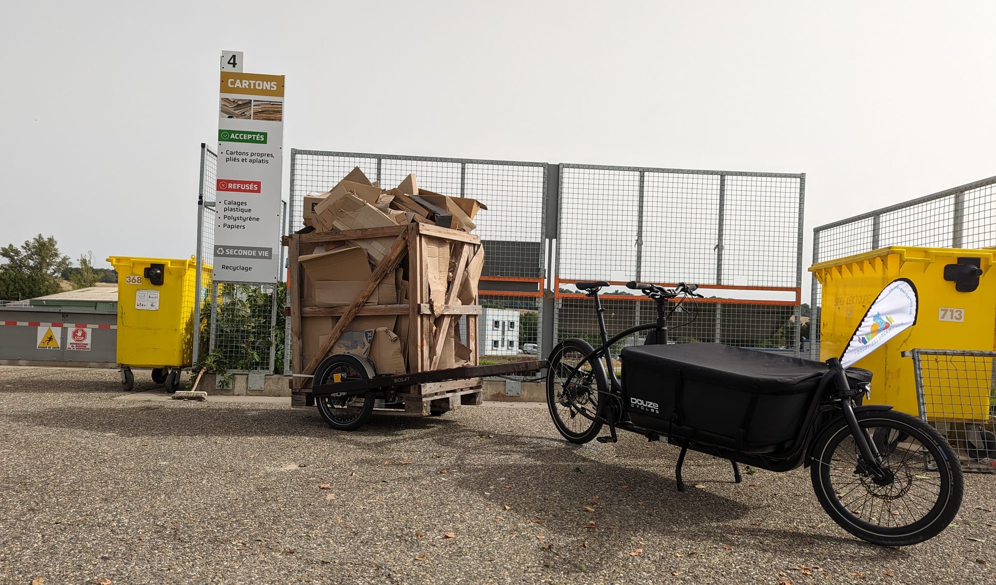 Un vélo cargo Douze V2 tirant une remorque Bicylift a conduit une caisse palette transportant des cartons à recycler à la déchèterie de la CC Lomagne Gersoise.