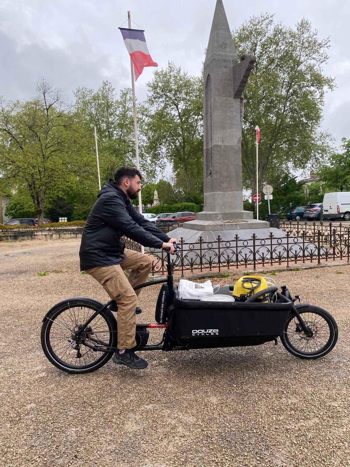 Un régisseur transportant du matériel dans la caisse d'un biporteur Douze V2