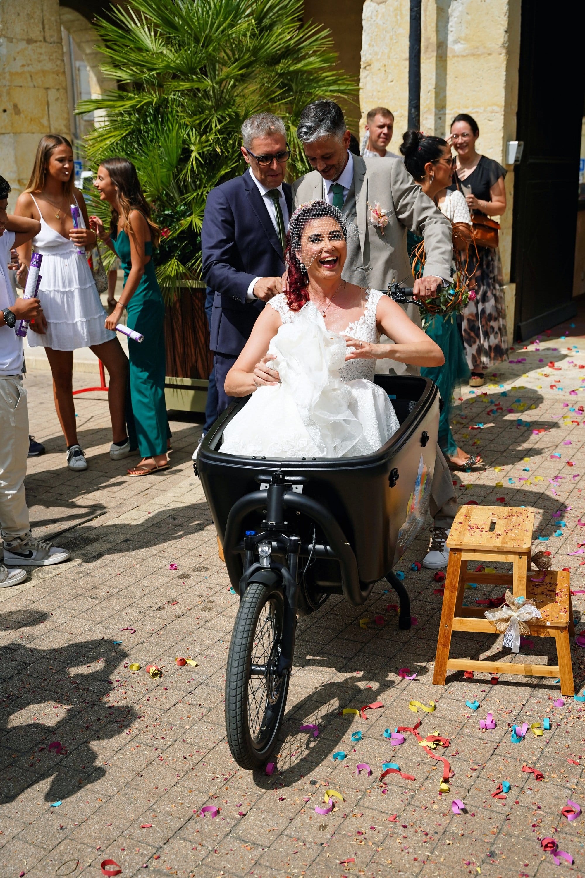Un marié s’apprête à démarrer son biporteur transportant une mariée dans la caisse avant.
