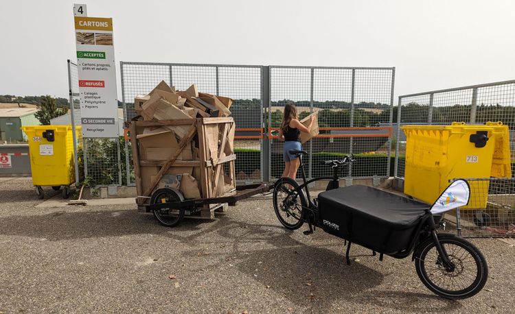 Un vélo cargo Douze V2 tirant une remorque Bicylift a conduit une caisse palette transportant des cartons à recycler dans une déchèterie.