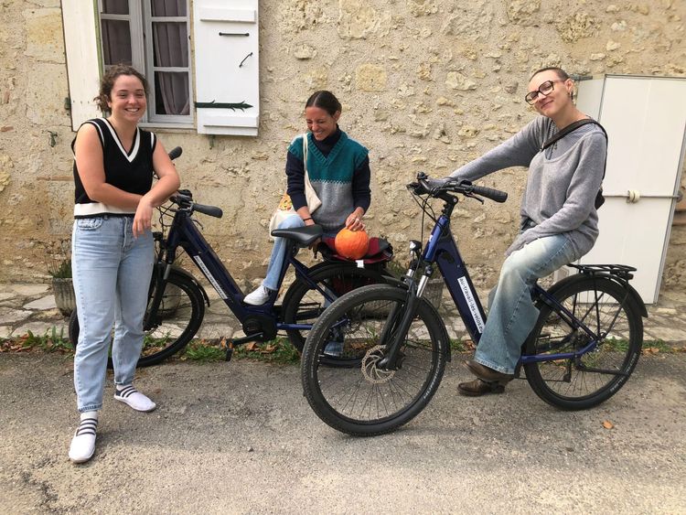Trois bénévoles de L’été photographique de Lectoure posent avec des VTC Peugeot EC01 prêtés par « Au travail les vélos ! »