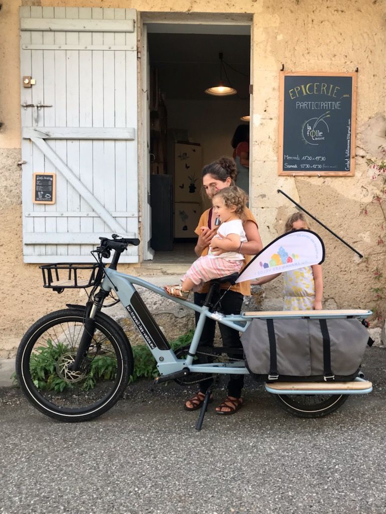 Photographie de la devanture de l'épicerie avec le vélo longtail R500E de chez décathlon