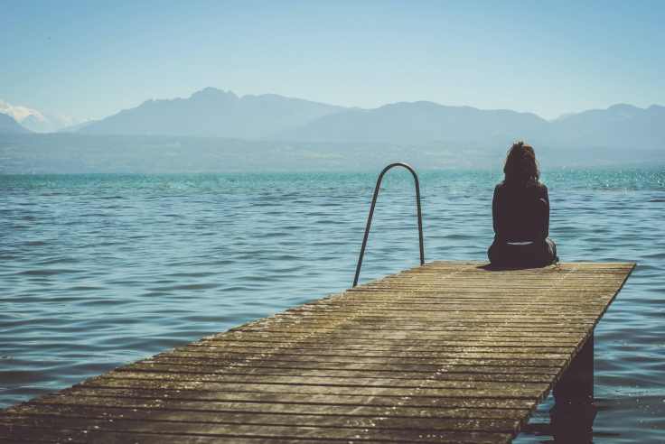woman sitting on dock during daytime