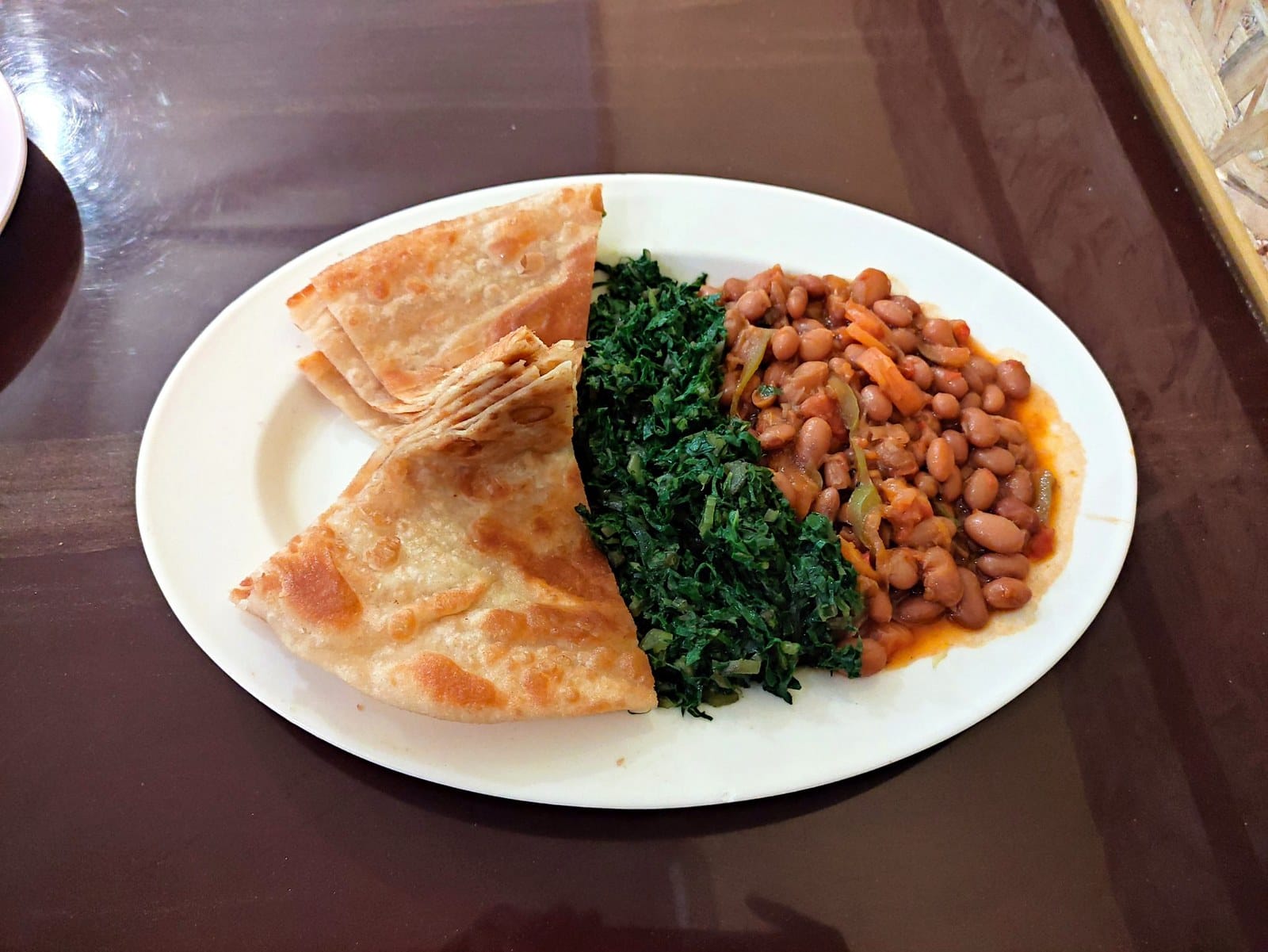 Chapati, sukuma wiki and beans — a Kenyan classic · Photo: Norman Mithika / Wikimedia (CC0)