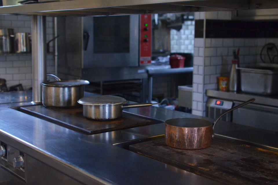 Pans sitting on the range in a stainless steel commercial kitchen