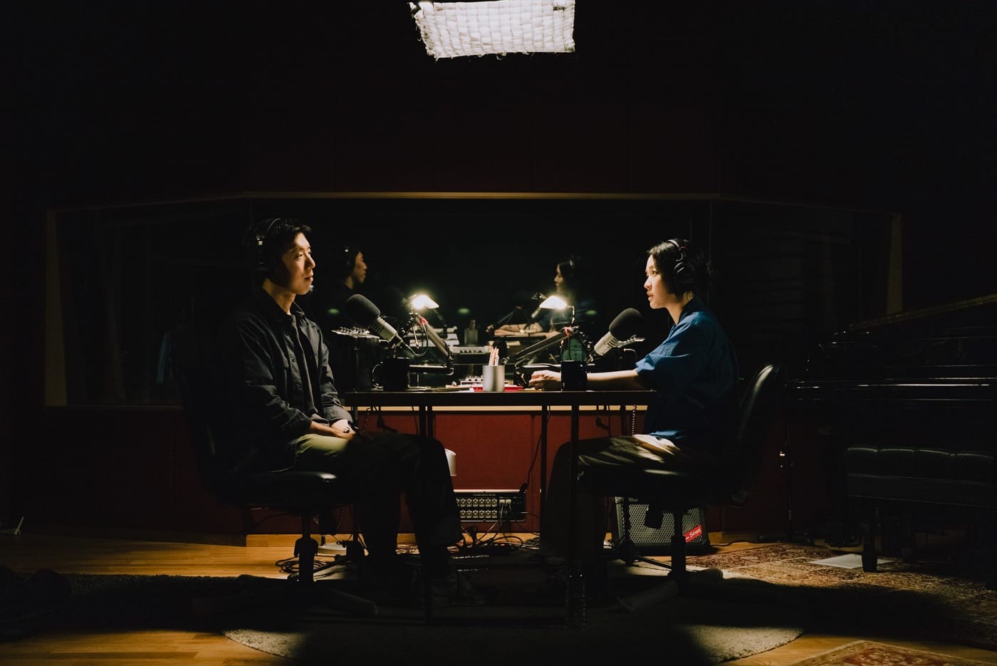 Two people recording an interview in a dark studio