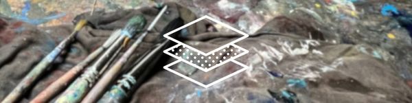 Art table with paintbrushes, t-shirt and paint splattered art table.