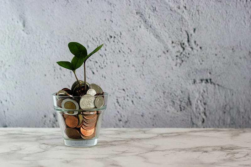 A small plant sprouts from money (coins) in a glass, representing insurance-covered mental health psychotherapy with coverage and billing restrictions.