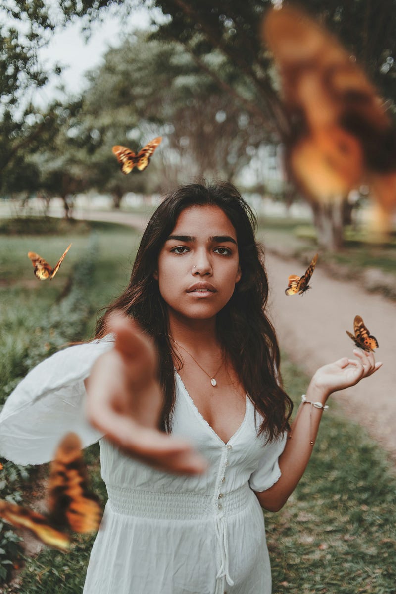 A high-achieving girl or woman looking uncertain, unsure, or confused is reaching out for help. Butterflies signal change, metamorphosis, or transformation around her, and one butterfly lands on her finger.