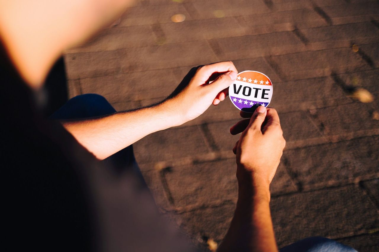 Person holding a vote sticker. Independent candidates and independent groups helping break out of the two-party duopoly.