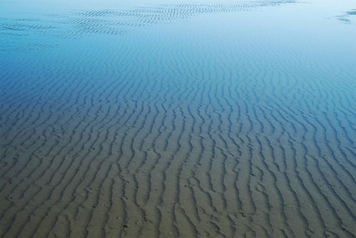 Photo of a shallow ocean pool with sand ripples