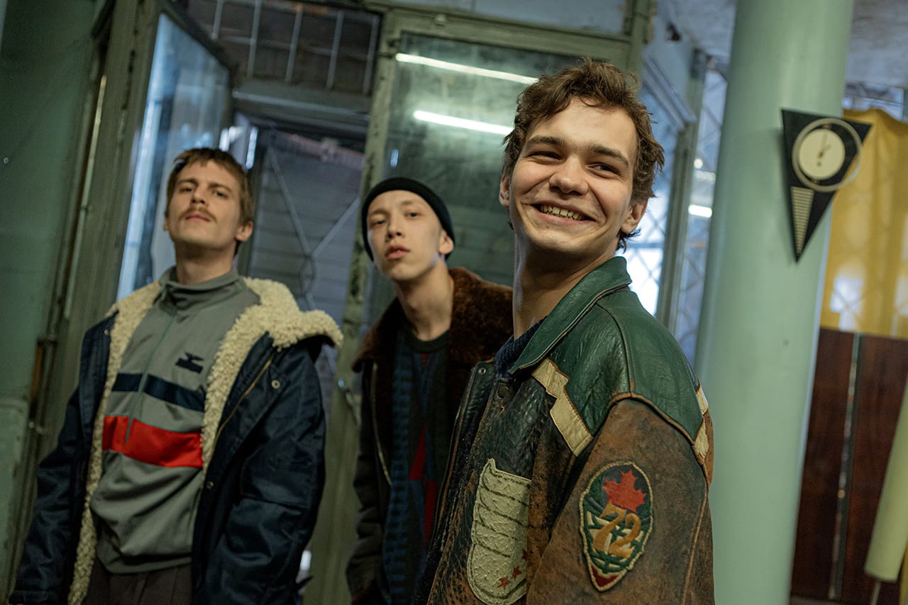 Сцена из сериала «Слово пацана. Кровь на асфальте». Вова Адидас, Зима и Турбо на входе в видеосалон