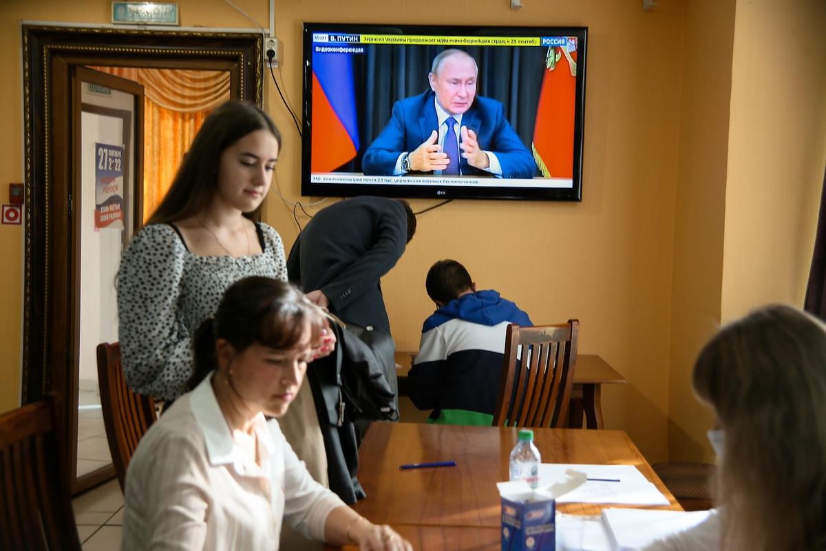 Голосование на фоне Путина в телевизоре