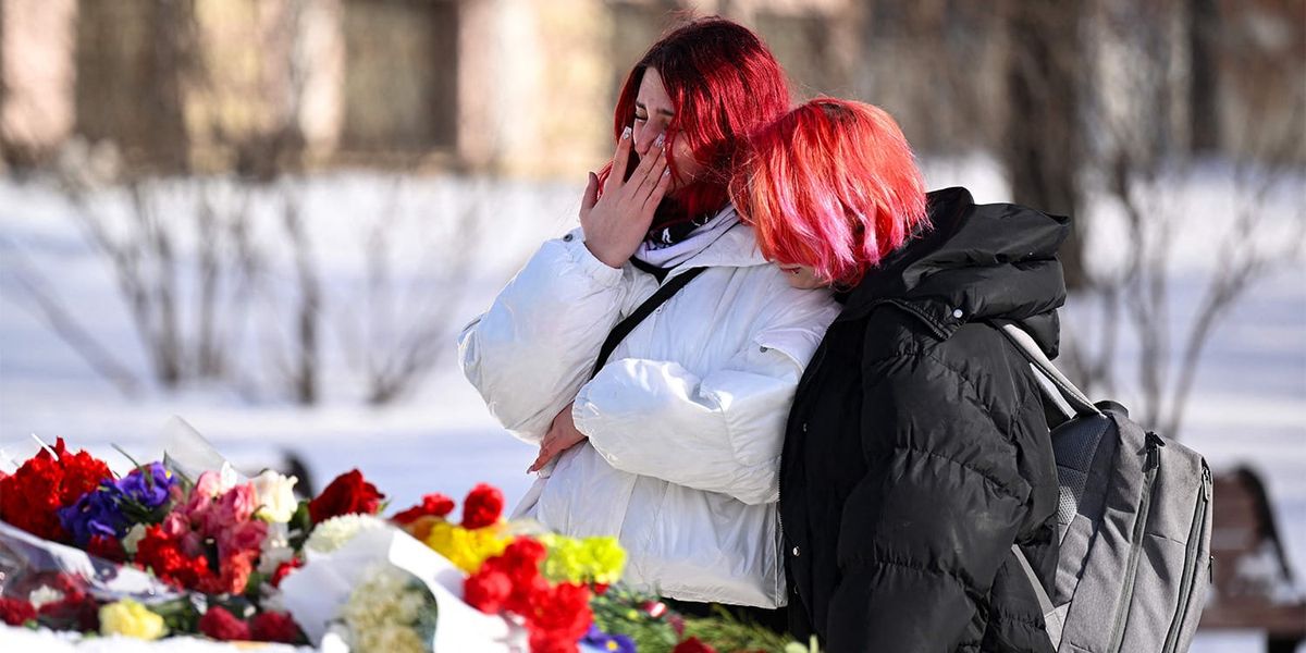 Девушки возлагают цветы в память Алексея Навального