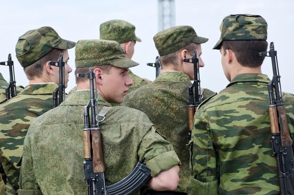 Молодые солдаты с автоматами "Калашников" стоят в строю.