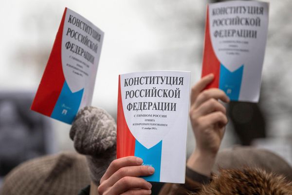 Руки, тянущие вверх Конституцию РФ