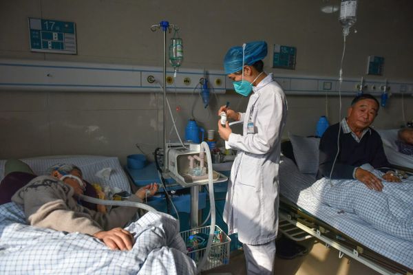 Врач рядом с пациентом в отделении COVID-19 в Китае