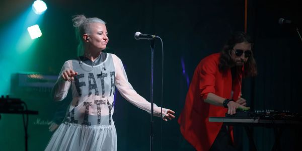 Мария Любичева, солистка группы «Барто», на сцене, справа — еще один участник группы за синтезатором