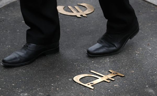 Золотые символы рубля и евро на асфальте