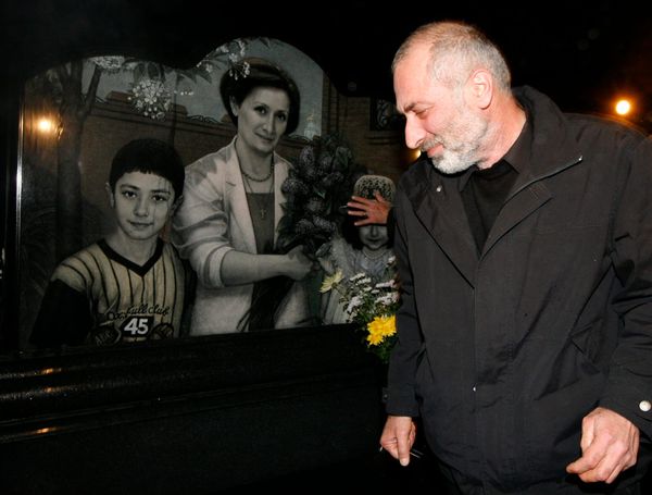 Виталий Калоев на могиле своей семьи