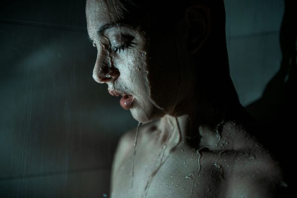 Капли воды на лице девушки в темноте