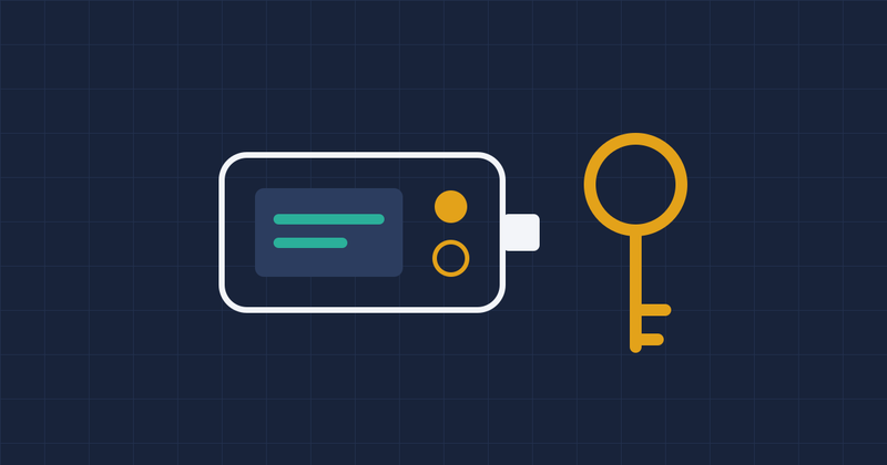 A hardware wallet device next to a gold key