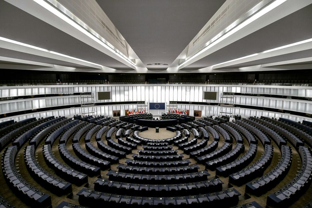 Overhead view of a circular plenary assembly chamber with concentric rows of delegate seats.